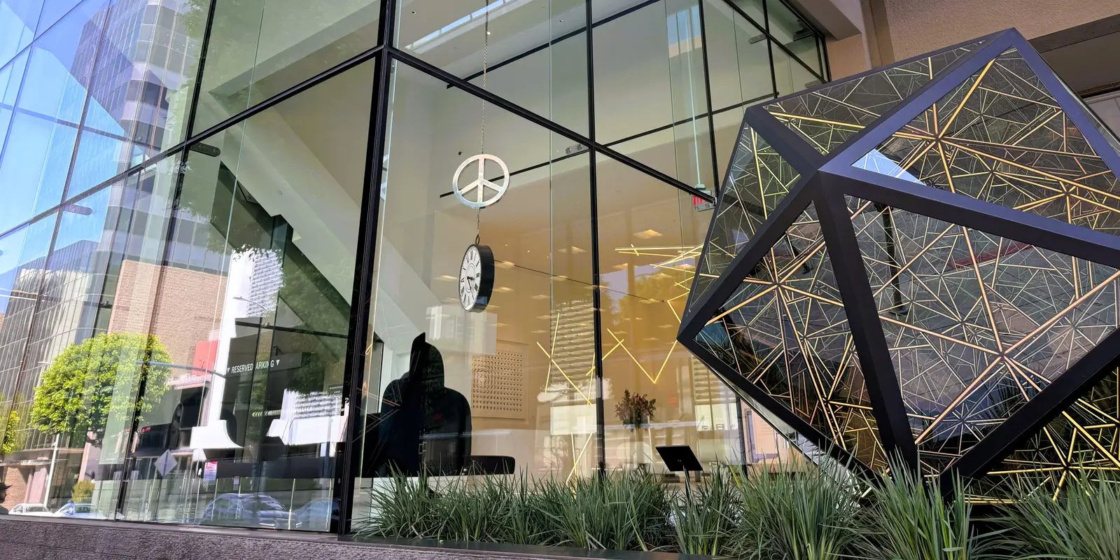 Glass facade and geometric sculpture outside the Beverly Hills office building at 433 N Camden Drive